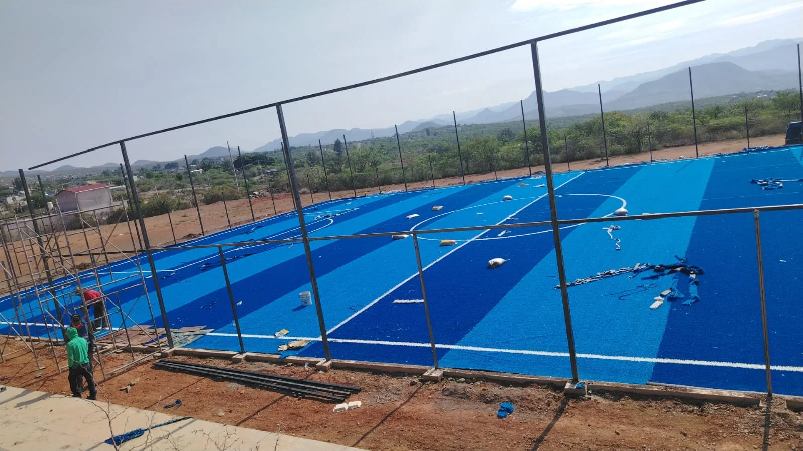 cancha azul con pasto sintético franjeado en instalación