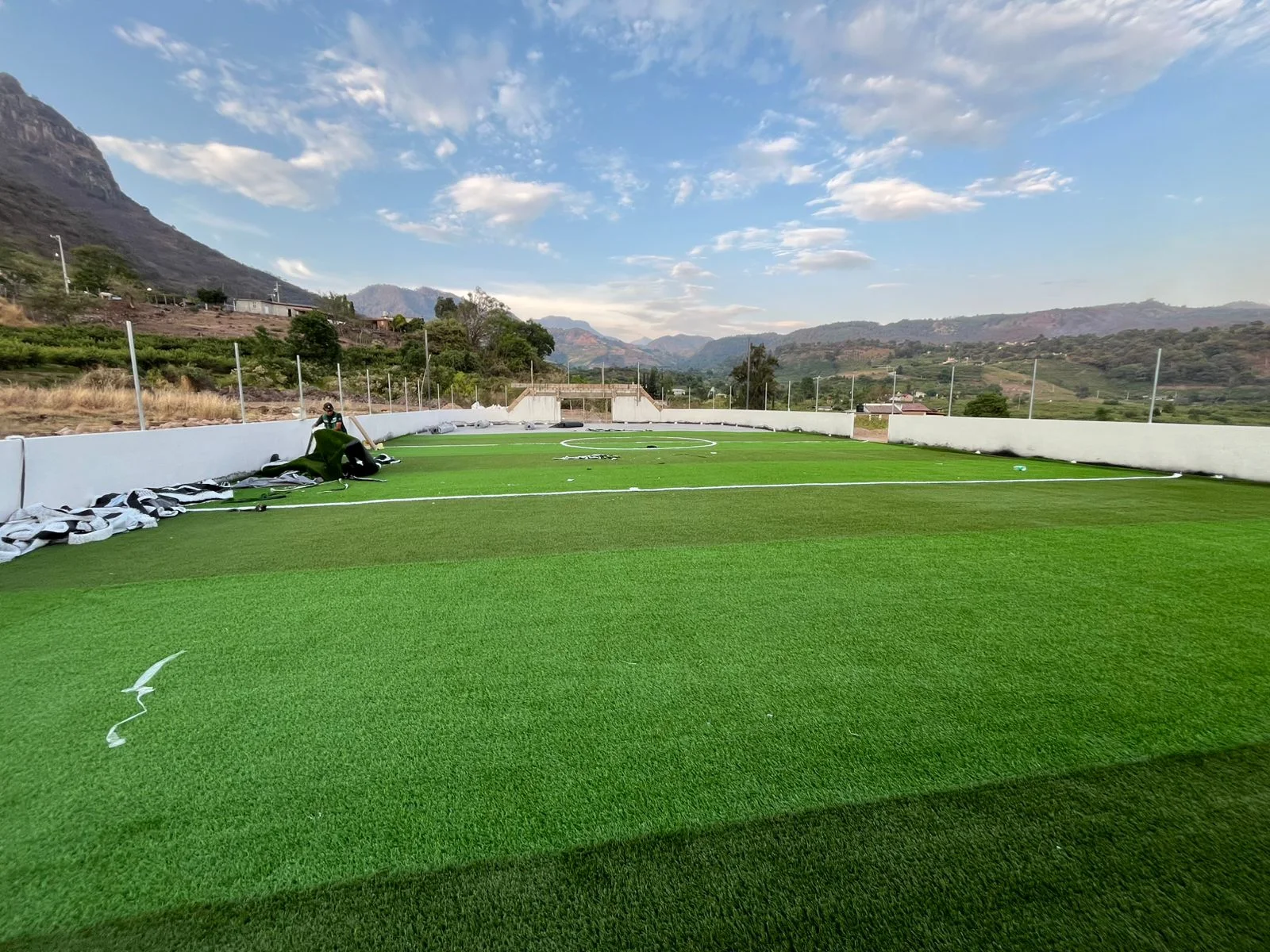 cancha deportiva con pasto sintético en instalación frente a montaña