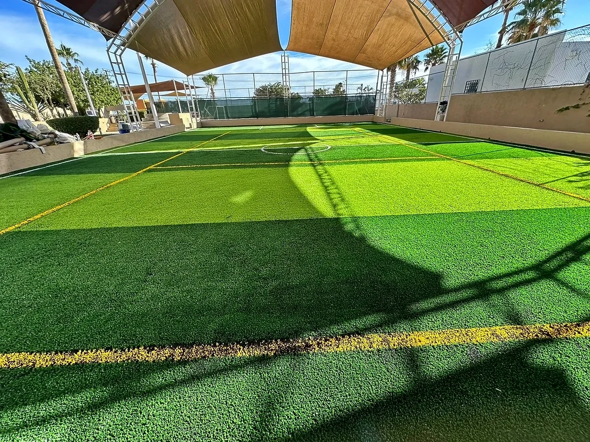 Cancha de fútbol 5 con pasto sintético en Instituto Peninsular, Cabo San Lucas, Baja California Sur: la cancha desde la línea lateral