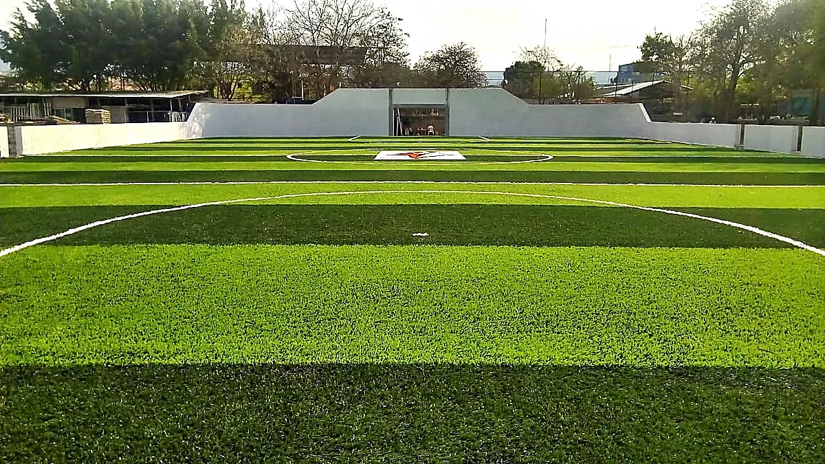 Cancha de fútbol rápido con pasto sintético en Escuela Primaria Pablo Guardado Chávez, Tuxtla Gutiérrez, Chiapas: líneas de juego insertadas en el pasto