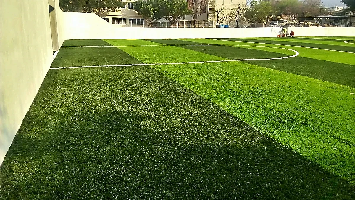 Cancha de fútbol rápido con pasto sintético en Escuela Primaria Pablo Guardado Chávez, Tuxtla Gutiérrez, Chiapas: pasto sintético deportivo recién cepillado