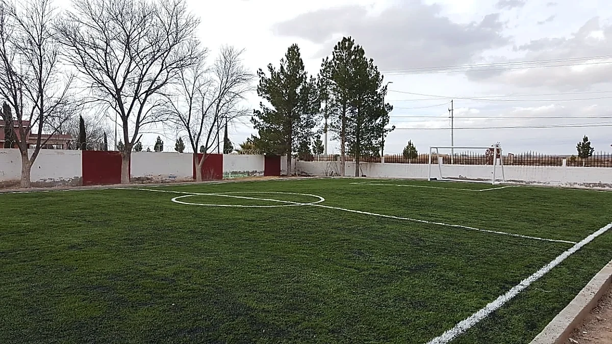 Cancha de fútbol 5 con pasto sintético en Praxedis, Chihuahua: la cancha desde la línea lateral