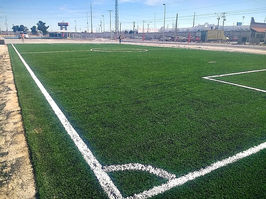 Cancha de fútbol 7 con pasto sintético en Maquila de Nexteer, Ciudad Juárez, Chihuahua: pasto sintético deportivo recién cepillado