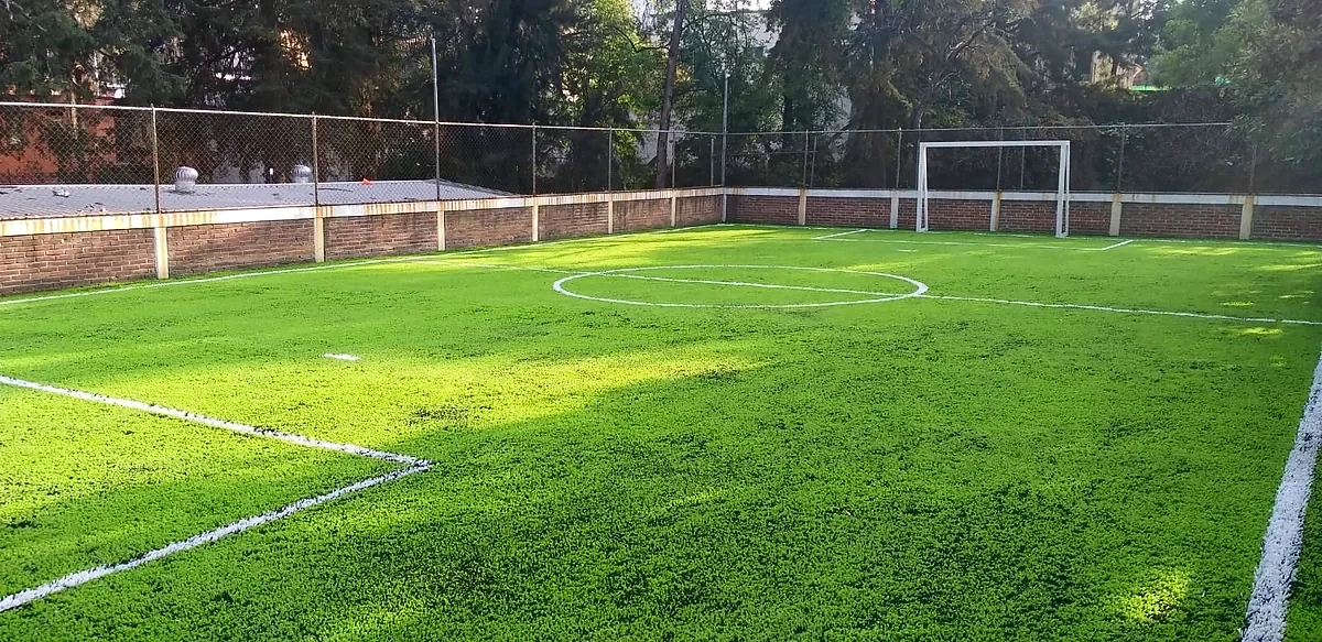 Cancha de fútbol 7 con pasto sintético en Niño IAP, Magdalena Contreras, Ciudad de México: la cancha desde la línea lateral
