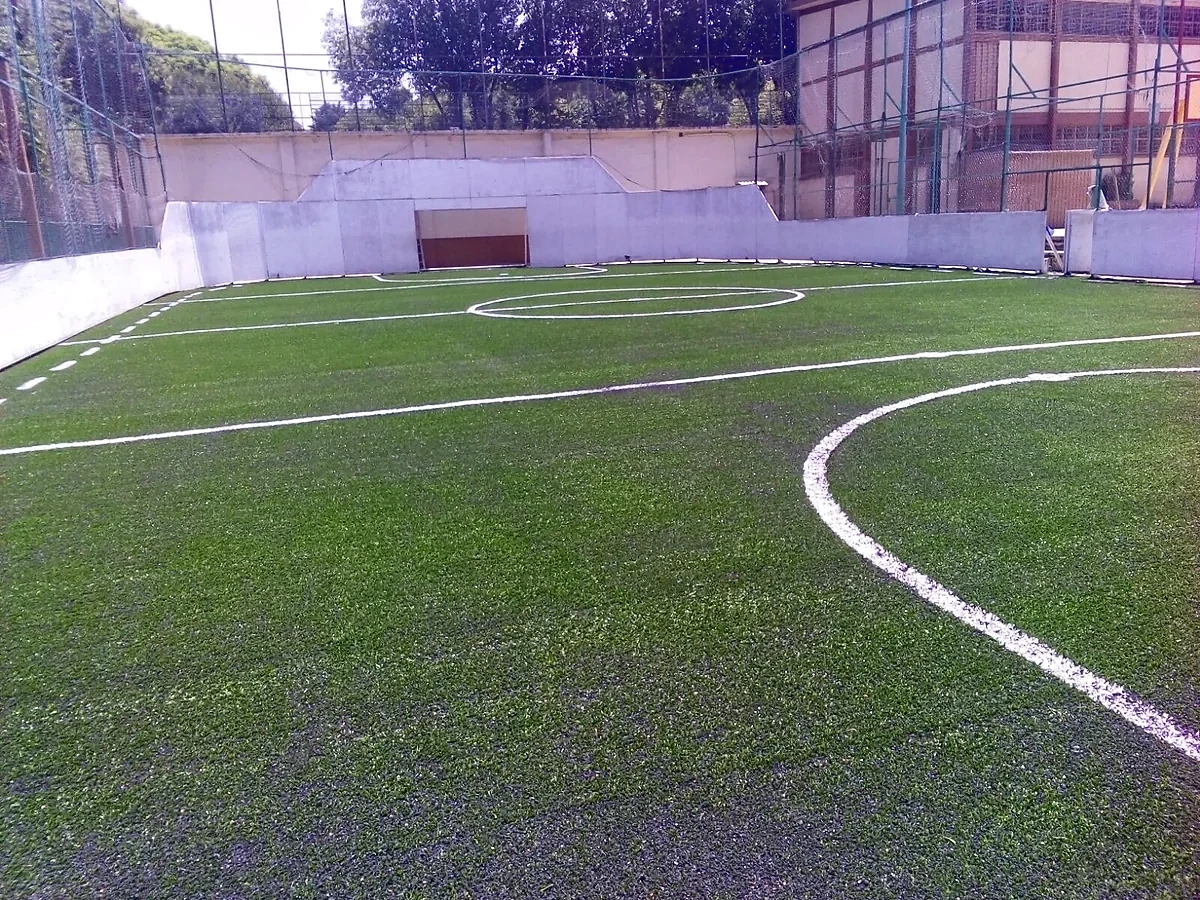 Cancha de fútbol rápido con pasto sintético en Colegio Salesiano, Popotla, Ciudad de México: líneas de juego insertadas en el pasto