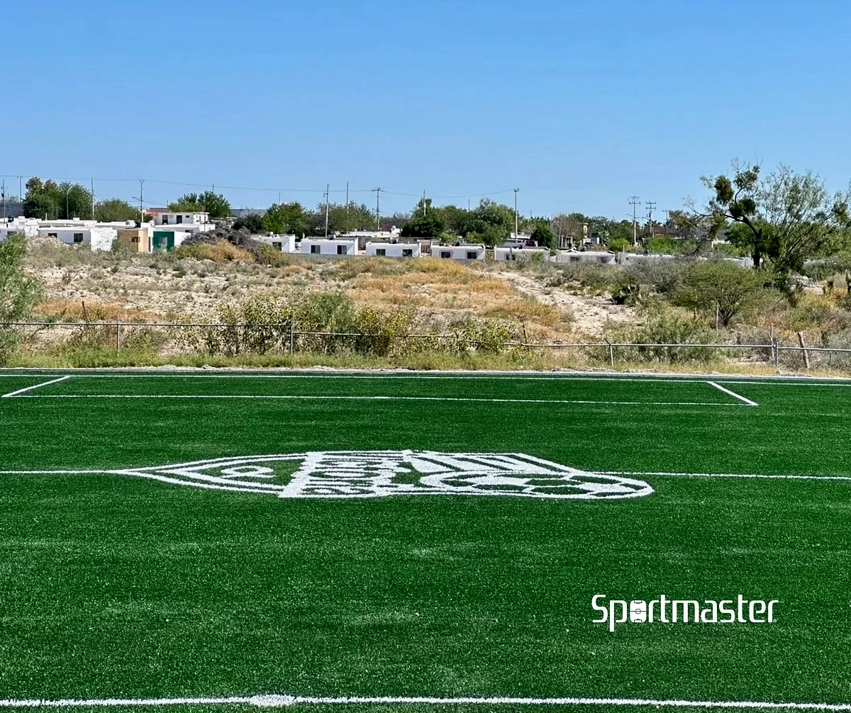Cancha de fútbol 7 con pasto sintético en Deportivo Biblioteca VID, Piedras Negras, Coahuila: la cancha desde la línea lateral