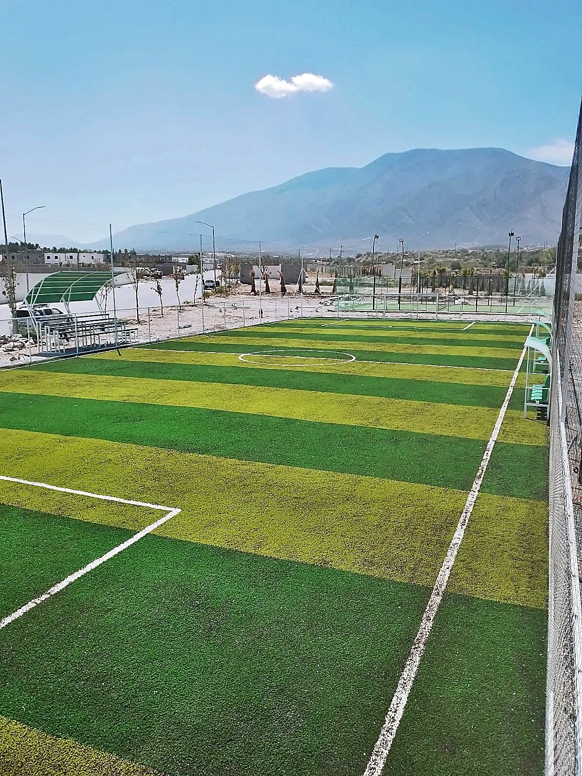 Cancha de fútbol 7 con pasto sintético en Fraccionamiento Santa Elena Residencial, Arteaga, Coahuila: la cancha desde la línea lateral