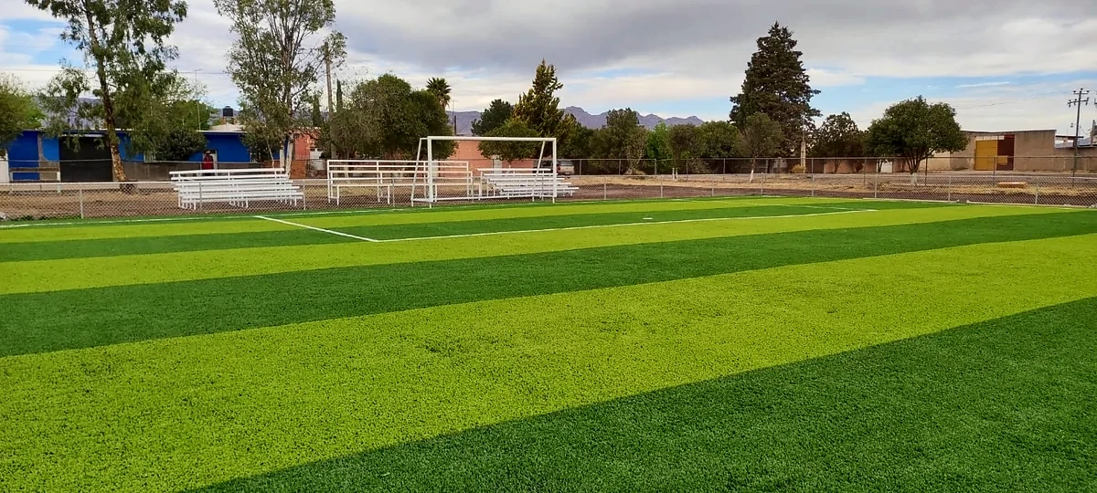 Cancha de fútbol 7 con pasto sintético en Escuela Primaria 20 de Noviembre, José Guadalupe Aguilera, Durango: pasto sintético deportivo recién cepillado