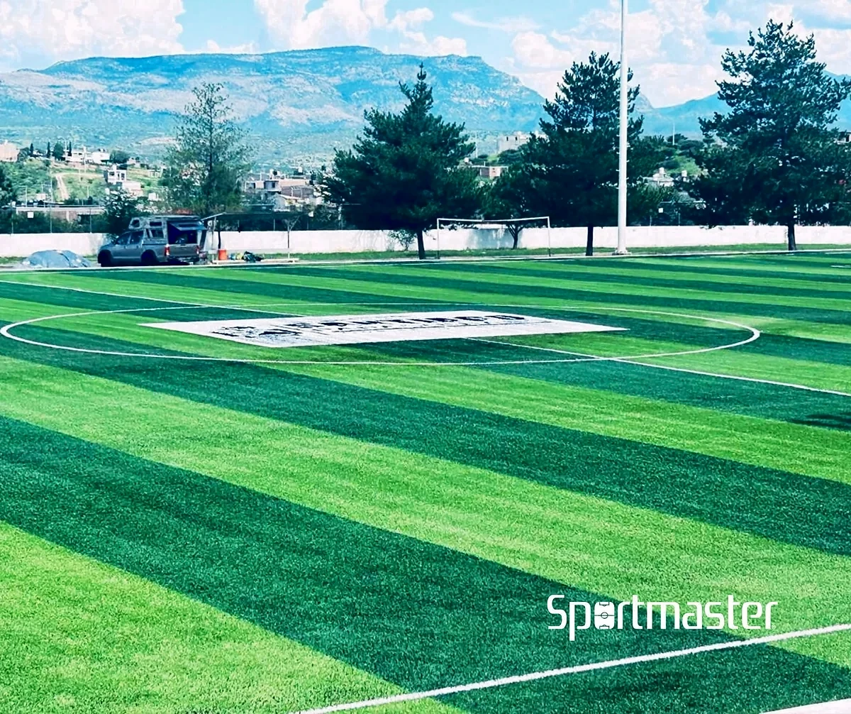 Cancha de fútbol soccer con pasto sintético en Deportivo Volcán, Santiago Papasquiaro, Durango: la cancha desde la línea lateral