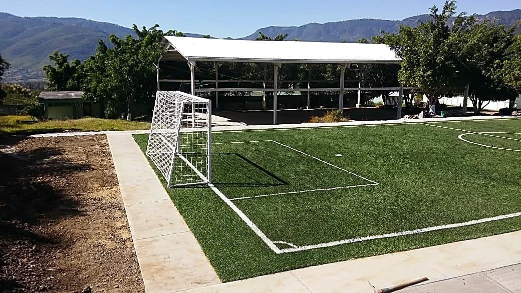 Cancha de fútbol 5 con pasto sintético en CBT Cuauhtinchán, Malinalco, Estado de México: la cancha desdel fondo