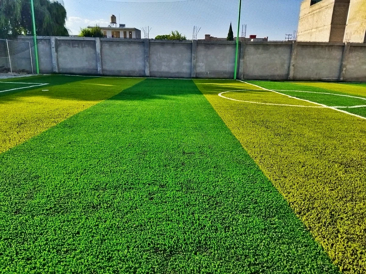 Cancha de fútbol 7 con pasto sintético en Cancha de Futbol la Roca, San Pedro Tultepec, Estado de México: la cancha desde la línea lateral