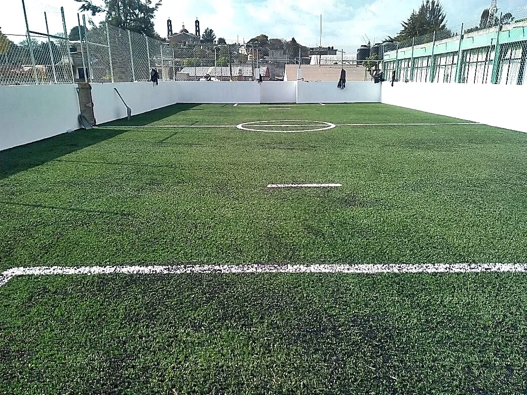 Cancha de fútbol 7 con pasto sintético en Esc. Primaria Benito Juárez, Zumpahuacan, Estado de México: líneas de juego insertadas en el mismo pasto
