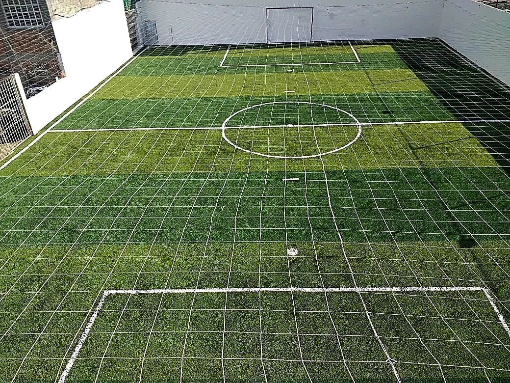 Cancha de fútbol rápido con pasto sintético en Cancha Deportiva Millán, Toluca, Estado de México: la cancha desde la línea lateral