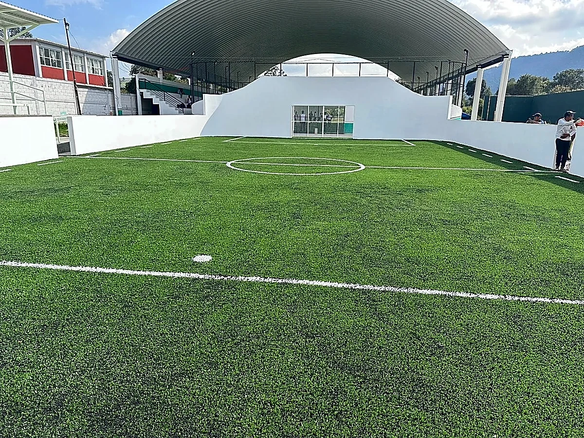 Cancha de fútbol rápido con pasto sintético en Deportivo Techuchulco, San Pedro Techuchulco, Estado de México: la cancha desdel fondo