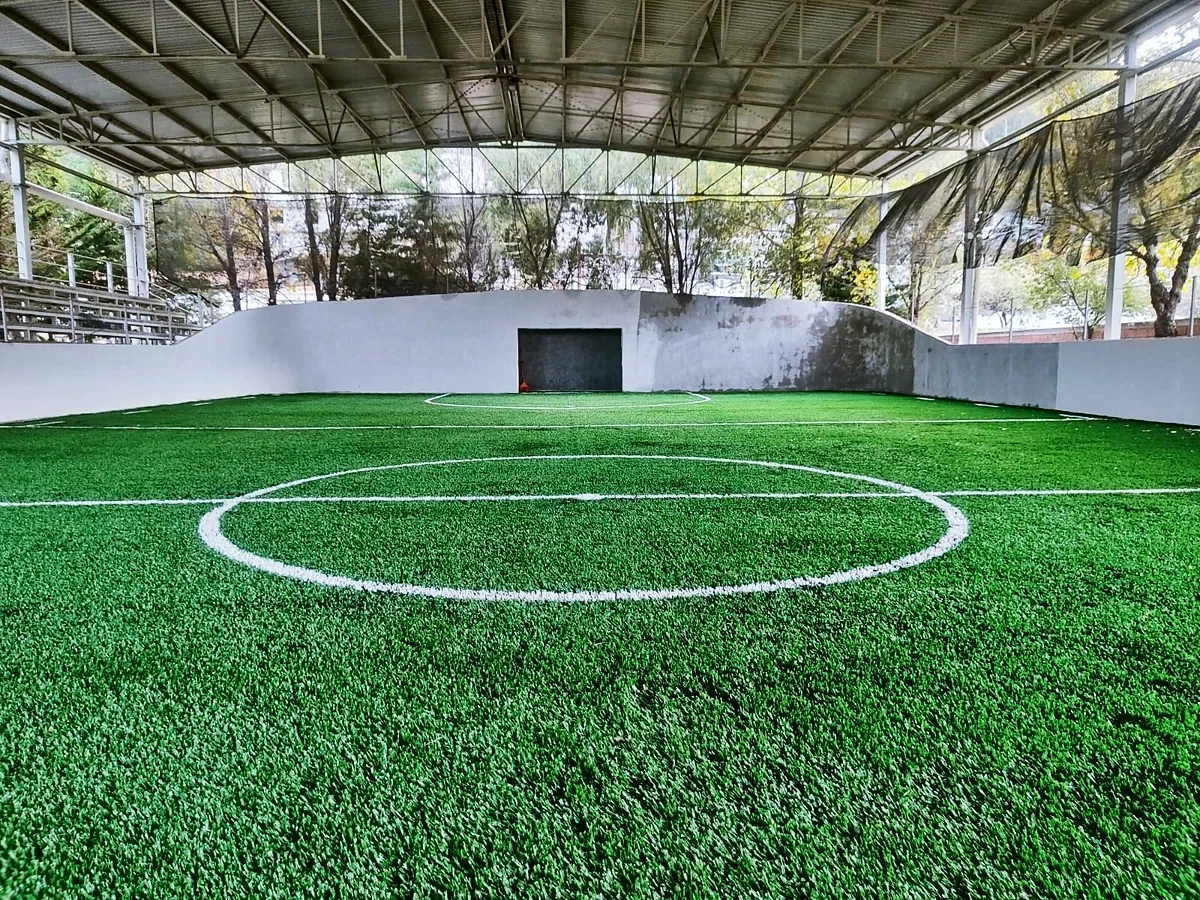 Cancha de fútbol rápido con pasto sintético en Unidad Deportiva la Cortina, Temascalcingo, Estado de México: líneas de juego insertadas en el pasto