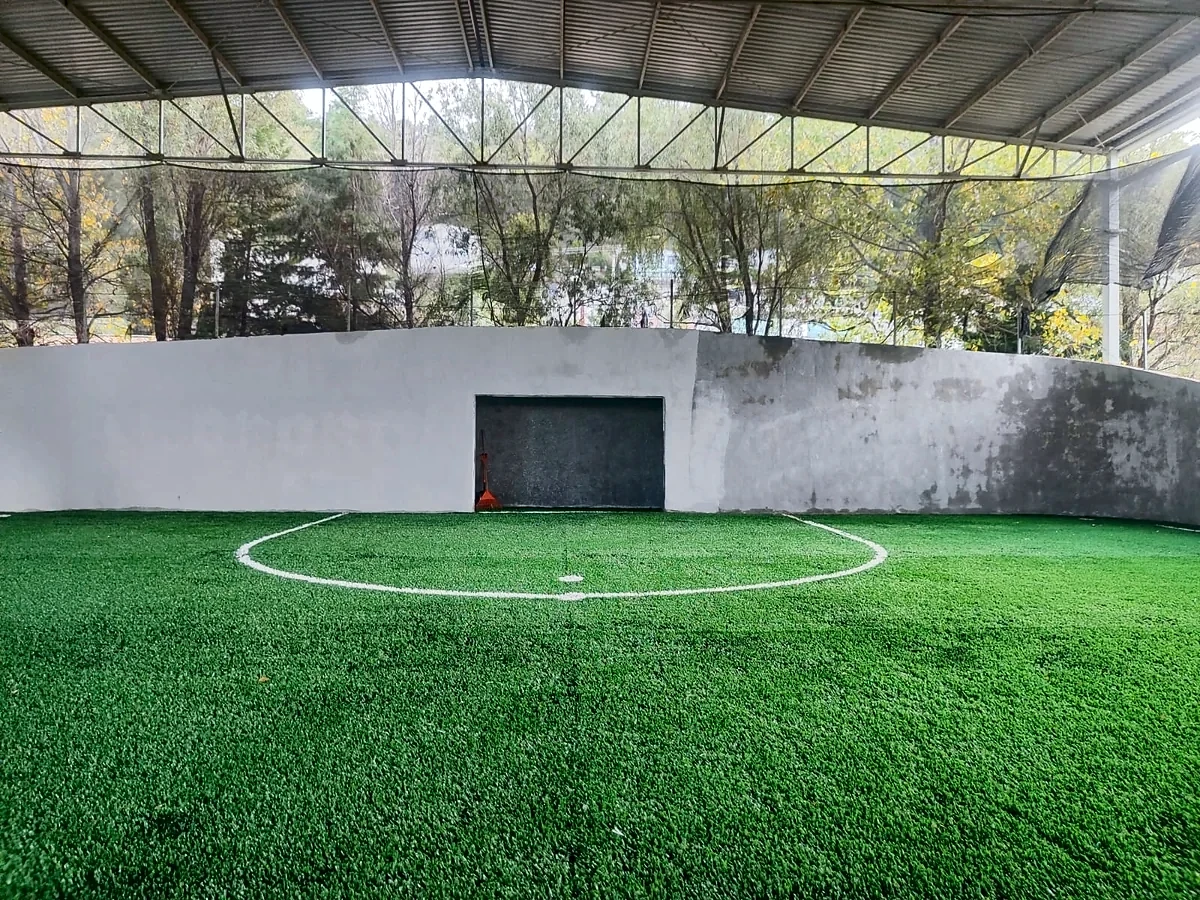 Cancha de fútbol rápido con pasto sintético en Unidad Deportiva la Cortina, Temascalcingo, Estado de México: la cancha desde la línea lateral