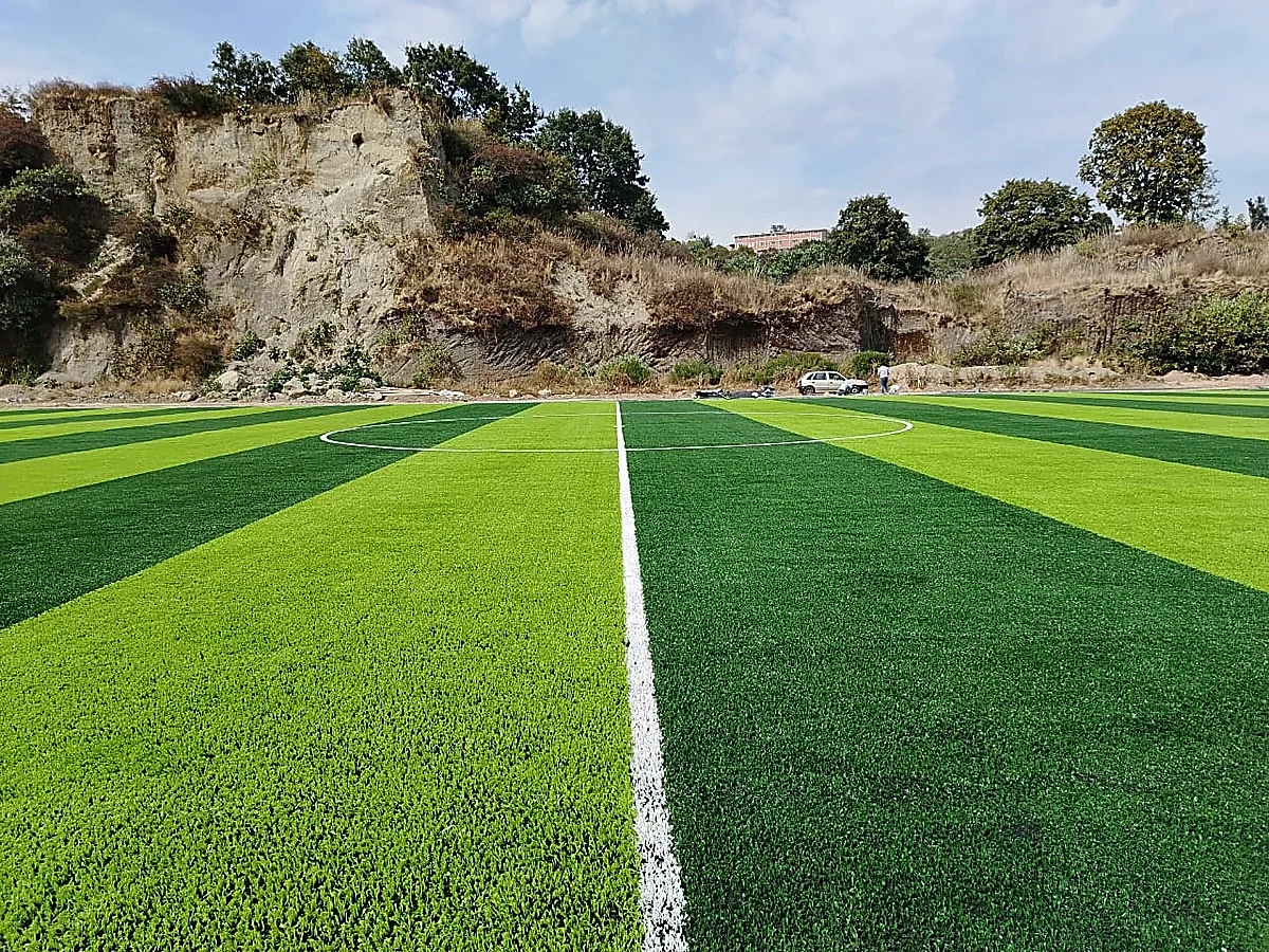 Cancha de fútbol soccer con pasto sintético en Tecnológico de Estudios Superiores de Huixquilucan, Estado de México: pasto sintético deportivo recién cepillado