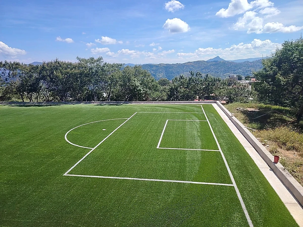 Cancha de fútbol 7 con pasto sintético en Escuela Primaria Bilingüe Emiliano Zapata, Temalacatzingo, Guerrero: la cancha desde la línea lateral