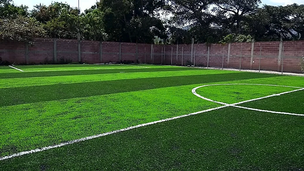 Cancha de fútbol 7 con pasto sintético en Tixtla, Guerrero: líneas de juego insertadas en el mismo pasto