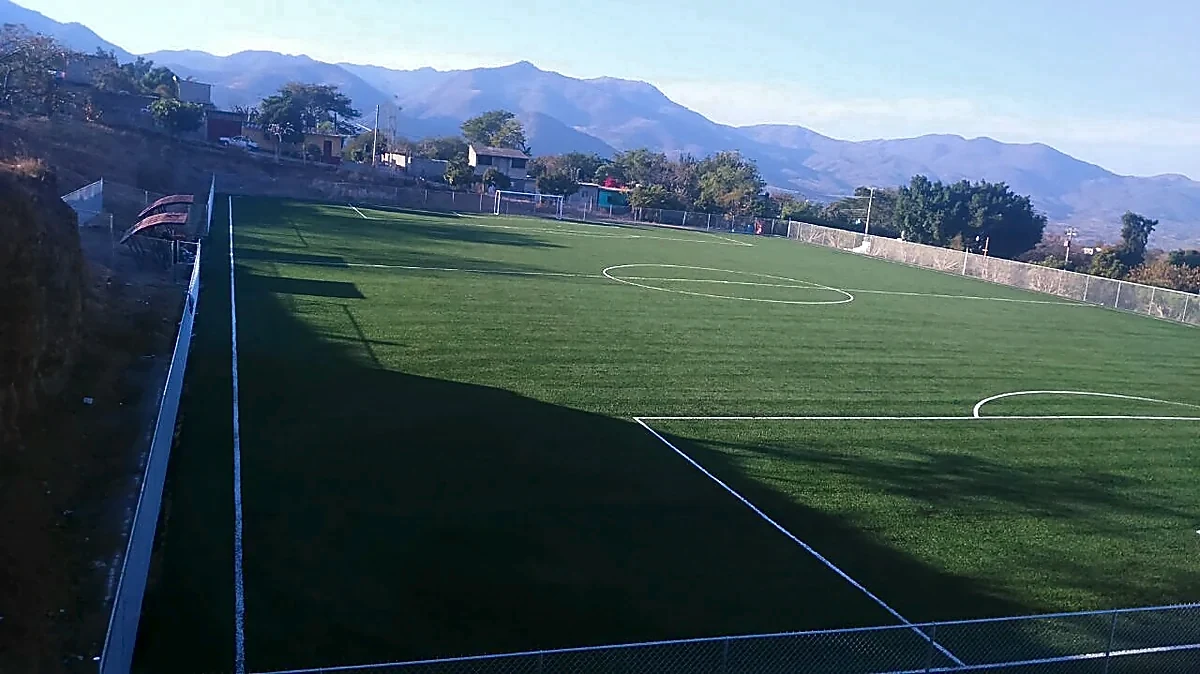 Cancha de fútbol soccer con pasto sintético en Campo deportivo de Peñoles, Apaxtla, Guerrero: pasto sintético deportivo recién cepillado