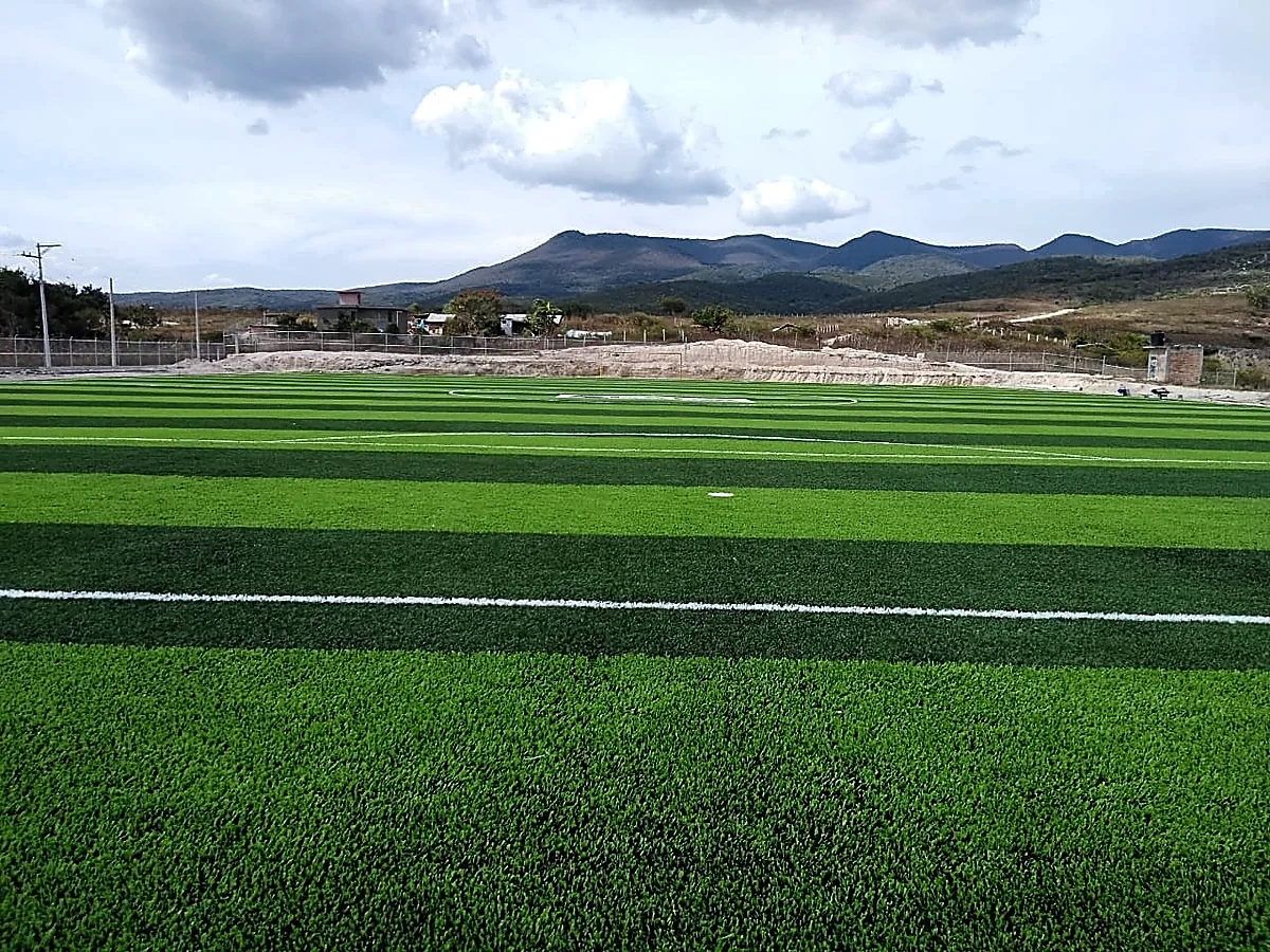 Cancha de fútbol soccer con pasto sintético en Unidad Deportiva de Tixtla, Tixtla (Atliaca), Guerrero: la cancha desde la línea lateral