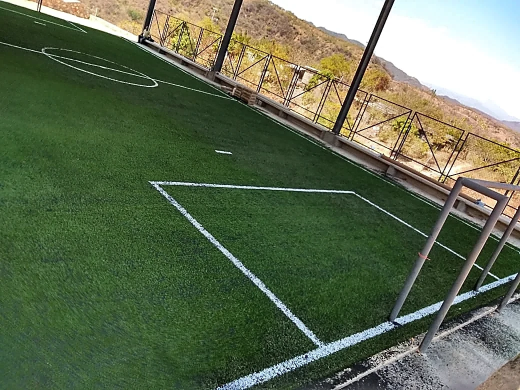 Cancha de fútbol 5 con pasto sintético y líneas insertadas bajo techumbre en una telesecundaria de Acapulco, Guerrero