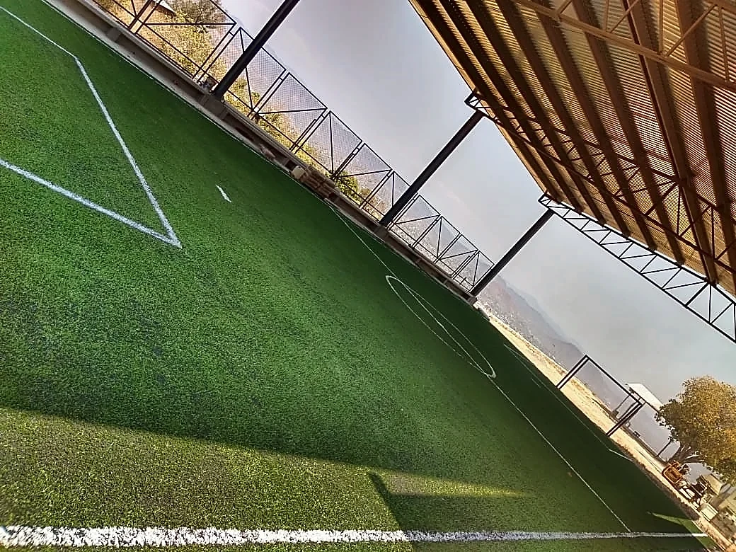 Techumbre metálica sobre la cancha de fútbol 5 con pasto sintético de una telesecundaria en Acapulco, Guerrero