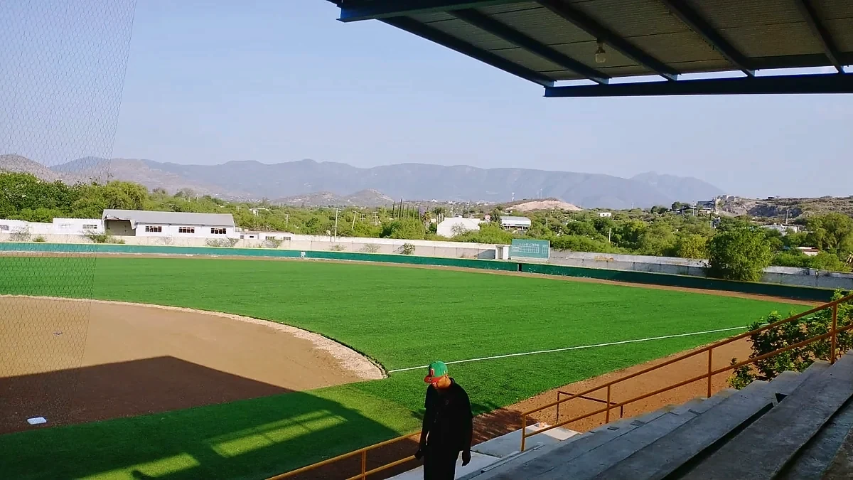 Jardín con pasto sintético y zona de advertencia en arcilla del Estadio de Béisbol Mineros de Zimapán, Hidalgo