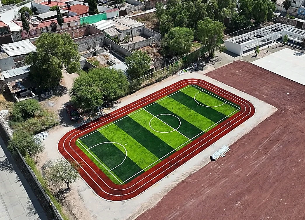 Cancha de fútbol 5 con pasto sintético en Colegio Jean Piaget de Actopan, Hidalgo: la cancha desde la línea lateral