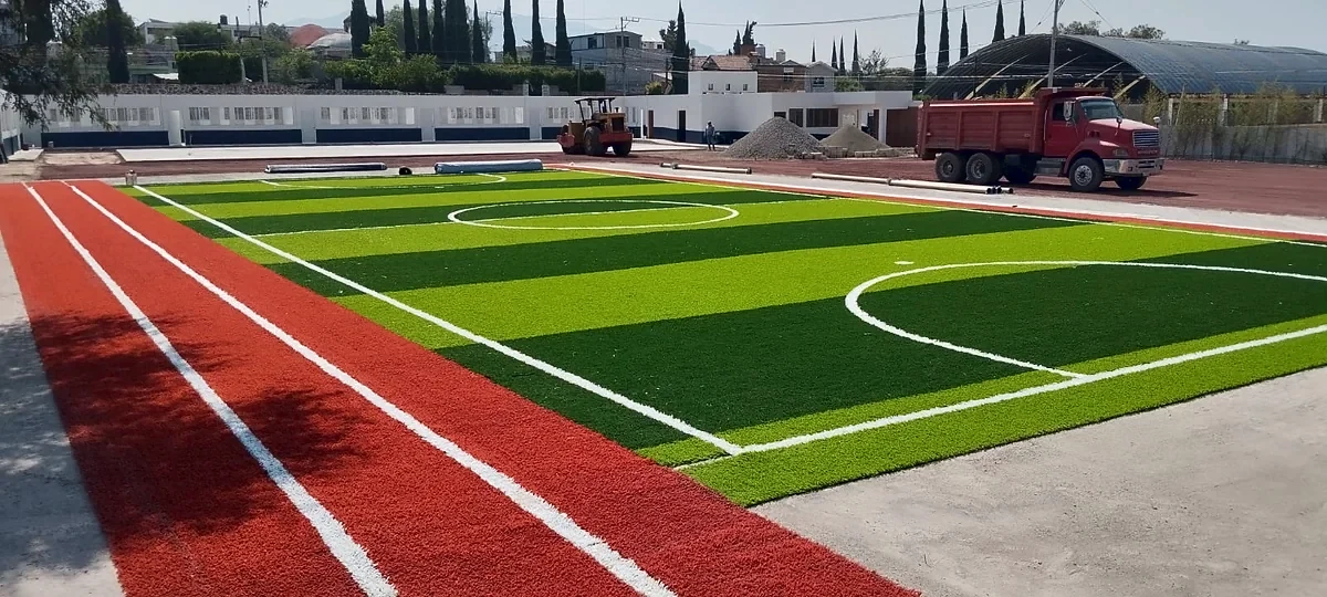Cancha de fútbol 5 con pasto sintético en Colegio Jean Piaget de Actopan, Hidalgo: pasto sintético deportivo recién cepillado