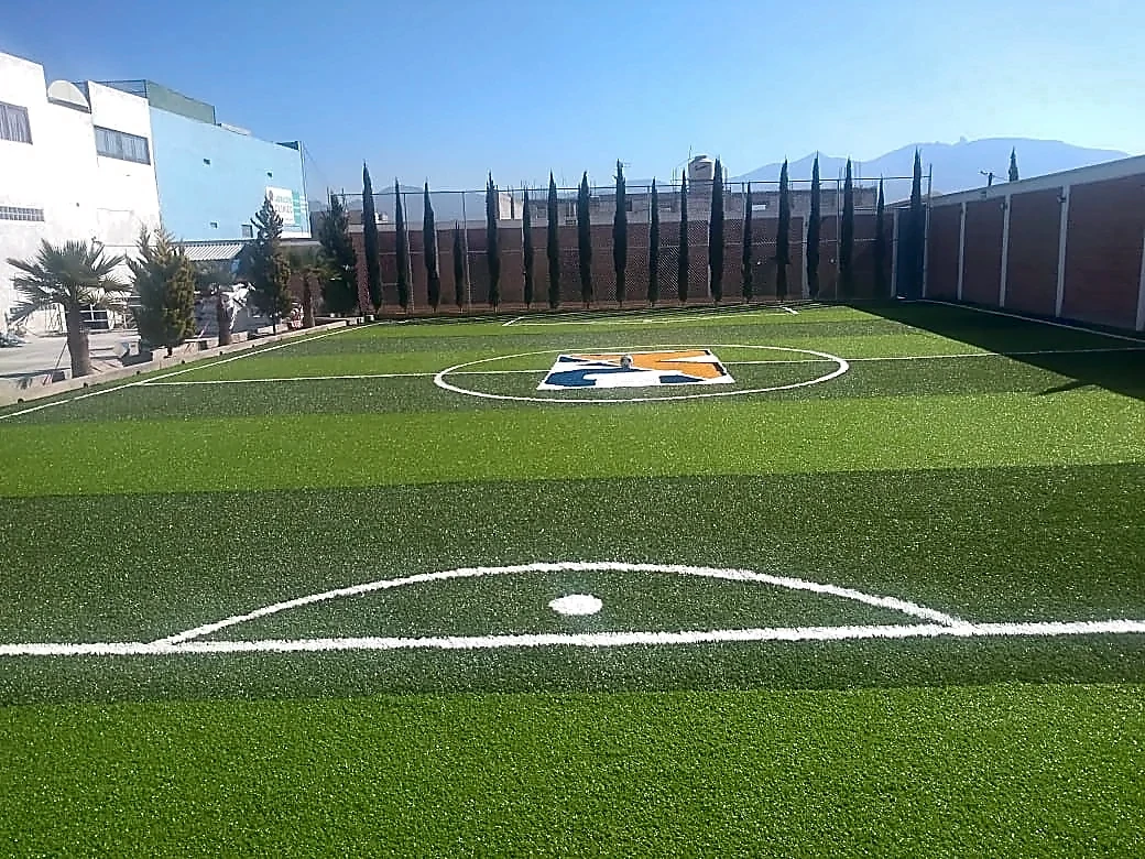 Cancha de fútbol 5 con pasto sintético en Secundaria Marie Curie, Actopan, Hidalgo: pasto sintético deportivo recién cepillado