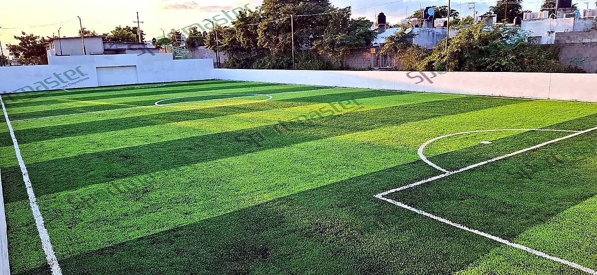 Esquina de cancha de fútbol rápido con pasto sintético y muro blanco en Ciudad Valles, San Luis Potosí