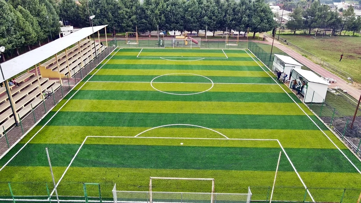 Cancha de fútbol 7 con pasto sintético en Complejo Deportivo Santa Clara del Cobre, Michoacán: la cancha desde la línea lateral