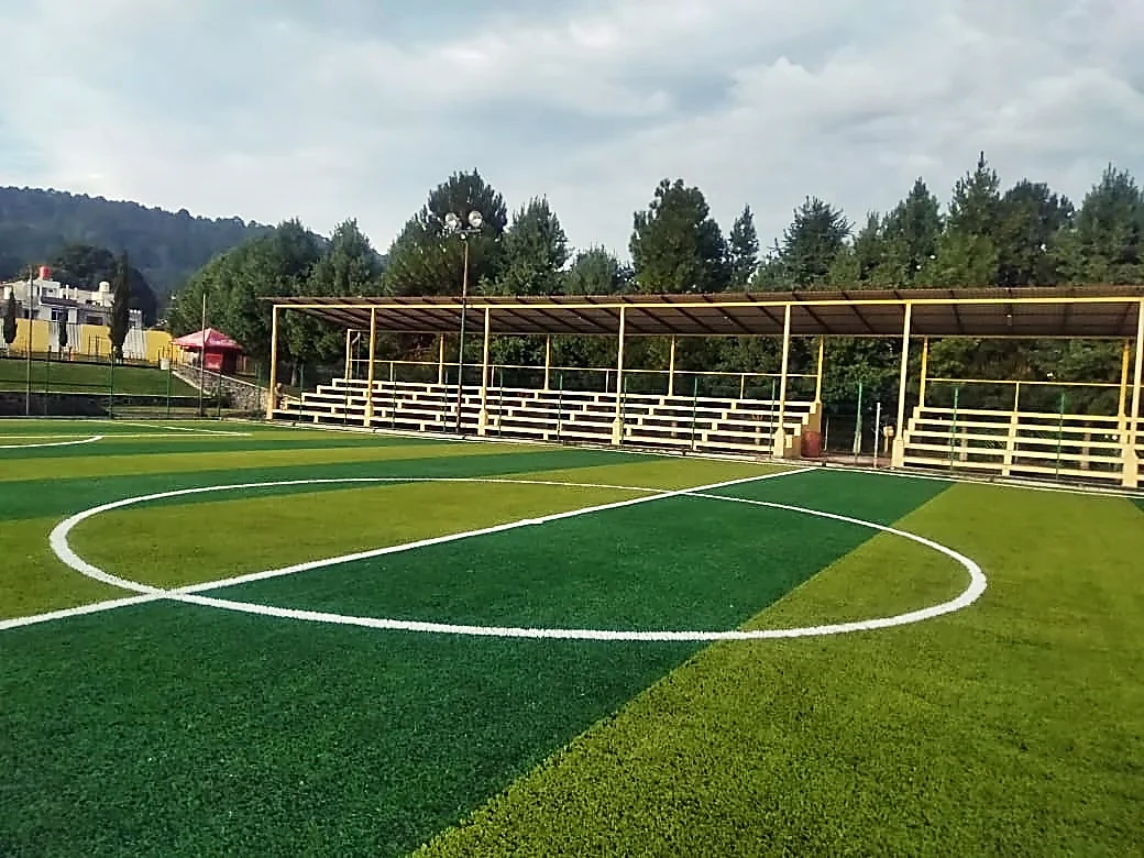 Cancha de fútbol 7 con pasto sintético en Complejo Deportivo Santa Clara del Cobre, Michoacán: la cancha desdel fondo