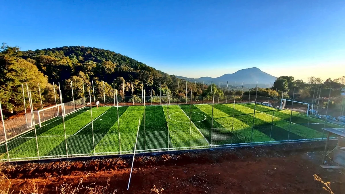 Cancha de fútbol 7 con pasto sintético en Salvador Escalante, Michoacán: líneas de juego insertadas en el mismo pasto