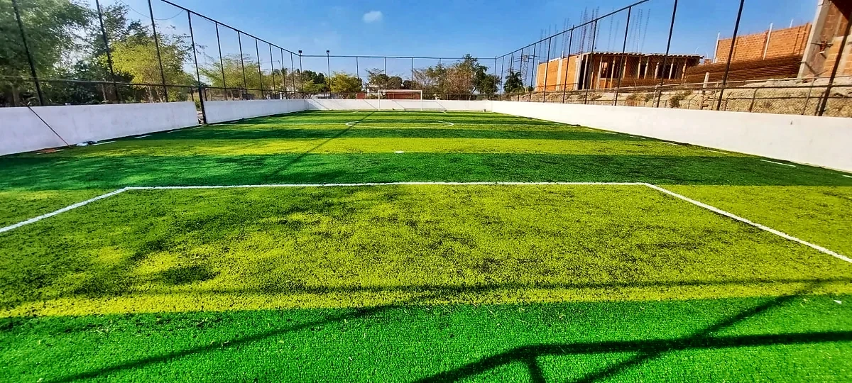 Cancha de fútbol rápido con pasto sintético en Tariácuri Sportclub, Lázaro Cárdenas, Michoacán: líneas de juego insertadas en el pasto