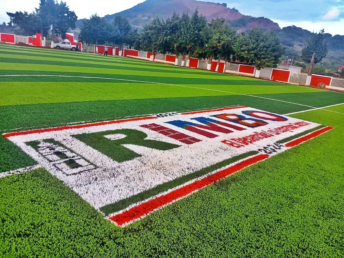Cancha de fútbol soccer con pasto sintético en Unidad Deportiva 18 de Marzo, Tzintzingareo (Irimbo), Michoacán: vista de la cancha y su entorno