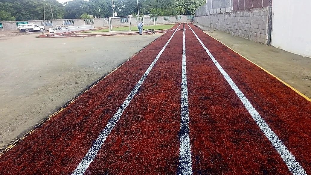 Pista para trotar con pasto sintético en Escuela Primaria y Secundaria José Vasconcelos, Lázaro Cárdenas, Michoacán: pasto sintético recién cepillado