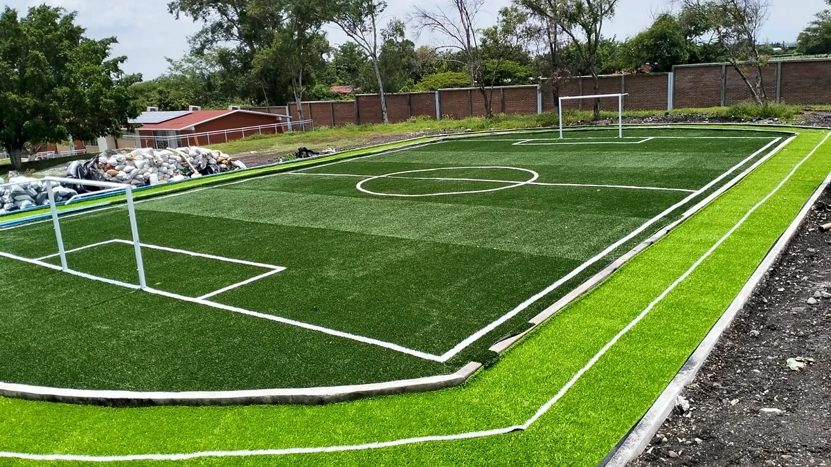 Cancha de fútbol 5 con pasto sintético en Escuela Primaria Miguel Hidalgo, Tlayecac, Morelos: líneas insertadas en el pasto sintético