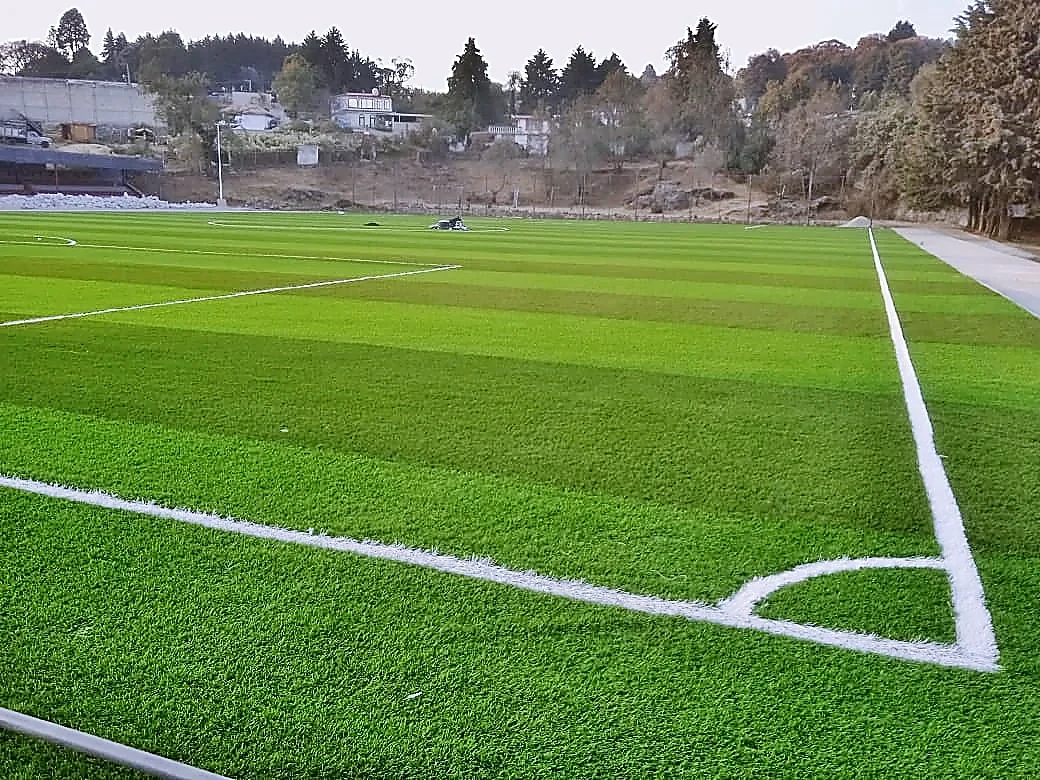 Cancha de fútbol soccer con pasto sintético en Unidad Deportiva Huitzilac, Morelos: vista de la cancha y su entorno