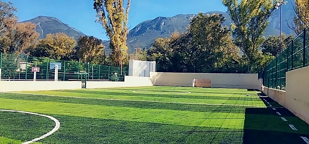 Cancha de fútbol 5 con pasto sintético en Unidad Deportiva Zaragoza, Nuevo León: la cancha desde la línea lateral