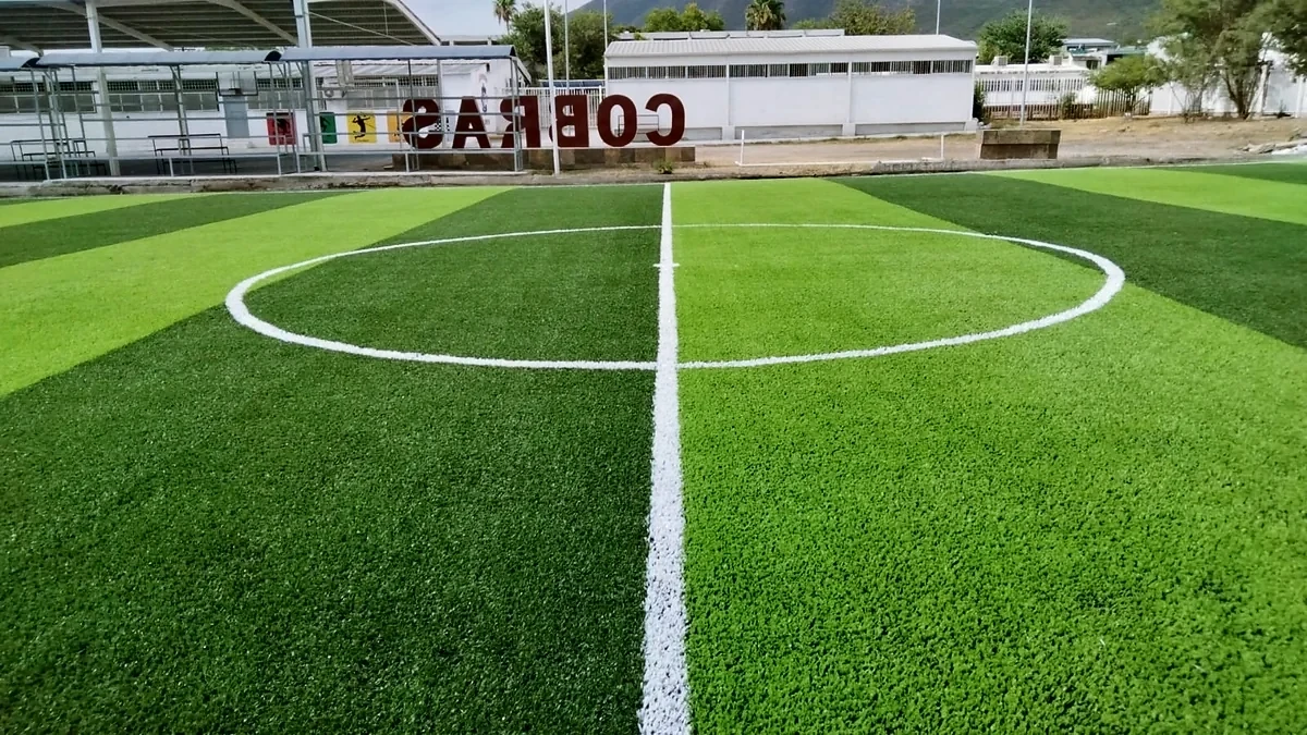 Cancha de fútbol 7 con pasto sintético en CBTIS 258, Escobedo, Nuevo León: pasto sintético deportivo recién cepillado