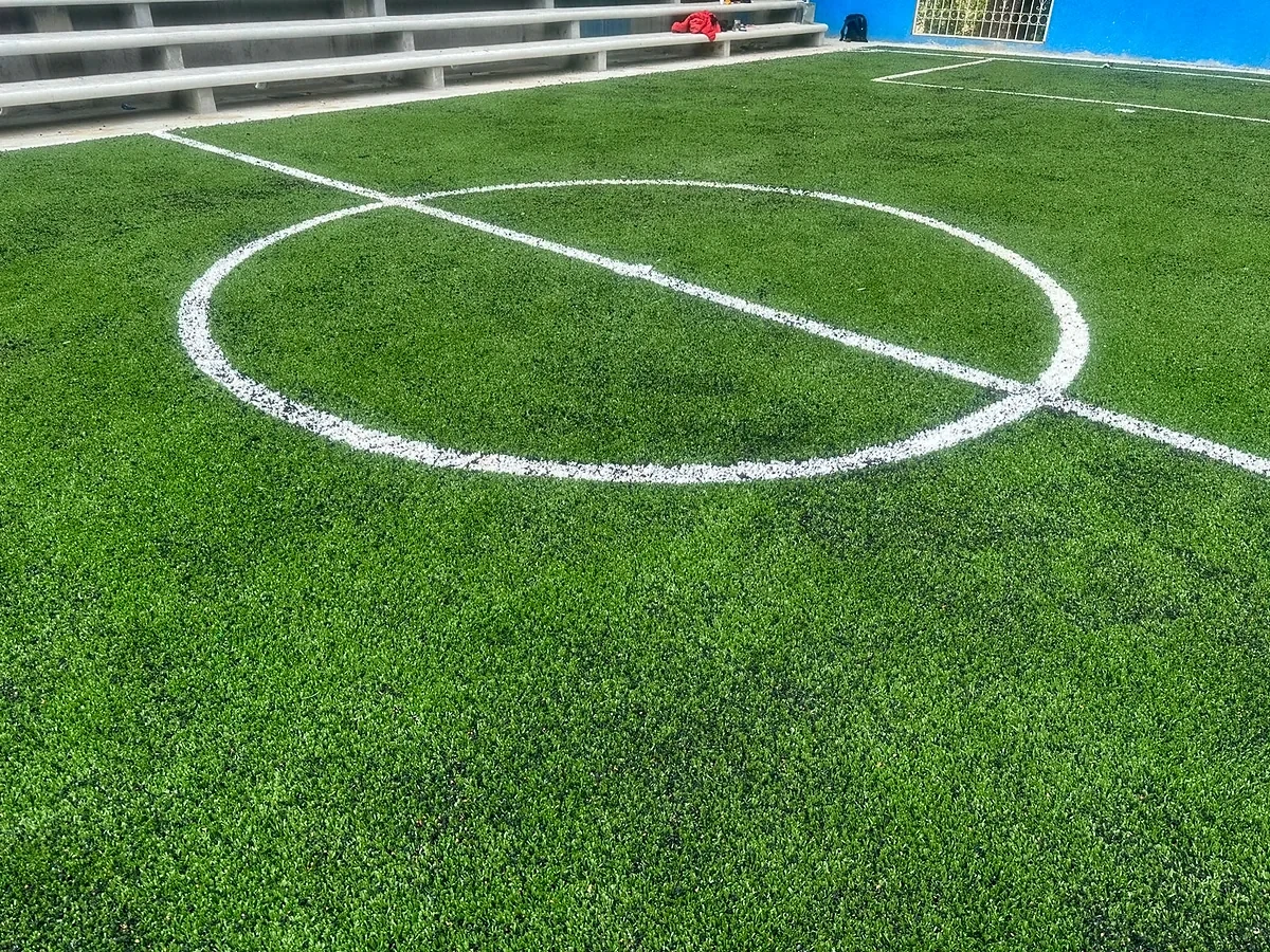 Cancha de fútbol 5 con pasto sintético en Primaria Carlos a Carrillo, Santa María Huazolotitlán, Oaxaca: la cancha desde la línea lateral