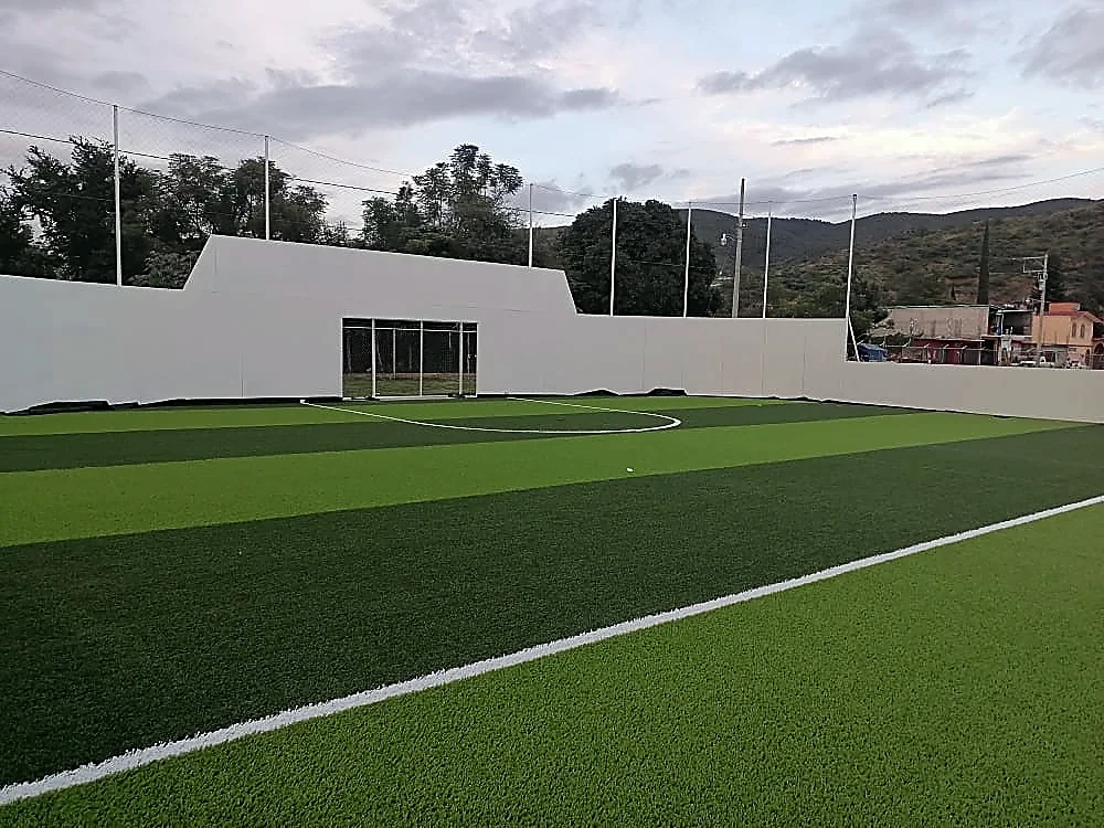 Cancha de fútbol 7 con pasto sintético en Ánimas Trujano, Oaxaca: líneas de juego insertadas en el mismo pasto