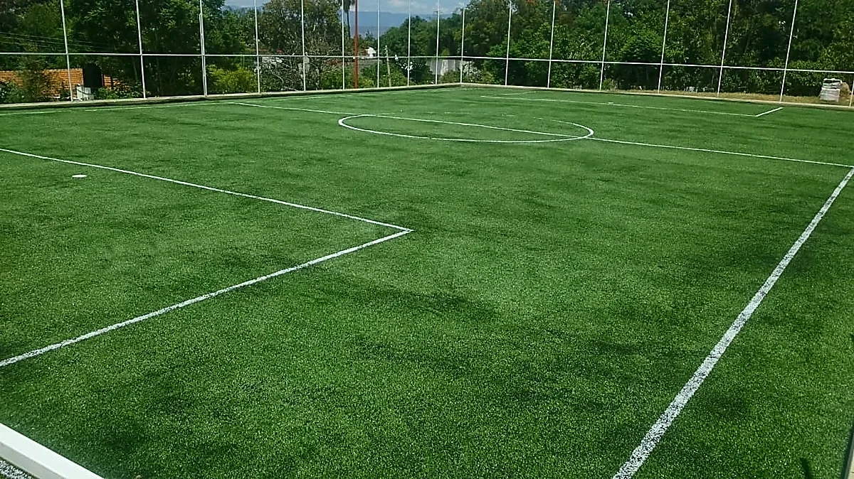 Cancha de fútbol 7 con pasto sintético en Campo Deportivo San Andres Huayapam, Oaxaca: la cancha desdel fondo