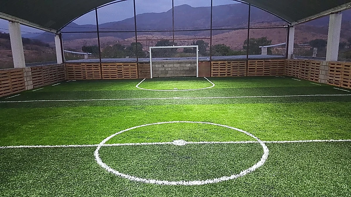 Cancha de fútbol rápido con pasto sintético en Huajolotitlán, Oaxaca: la cancha desde la línea lateral