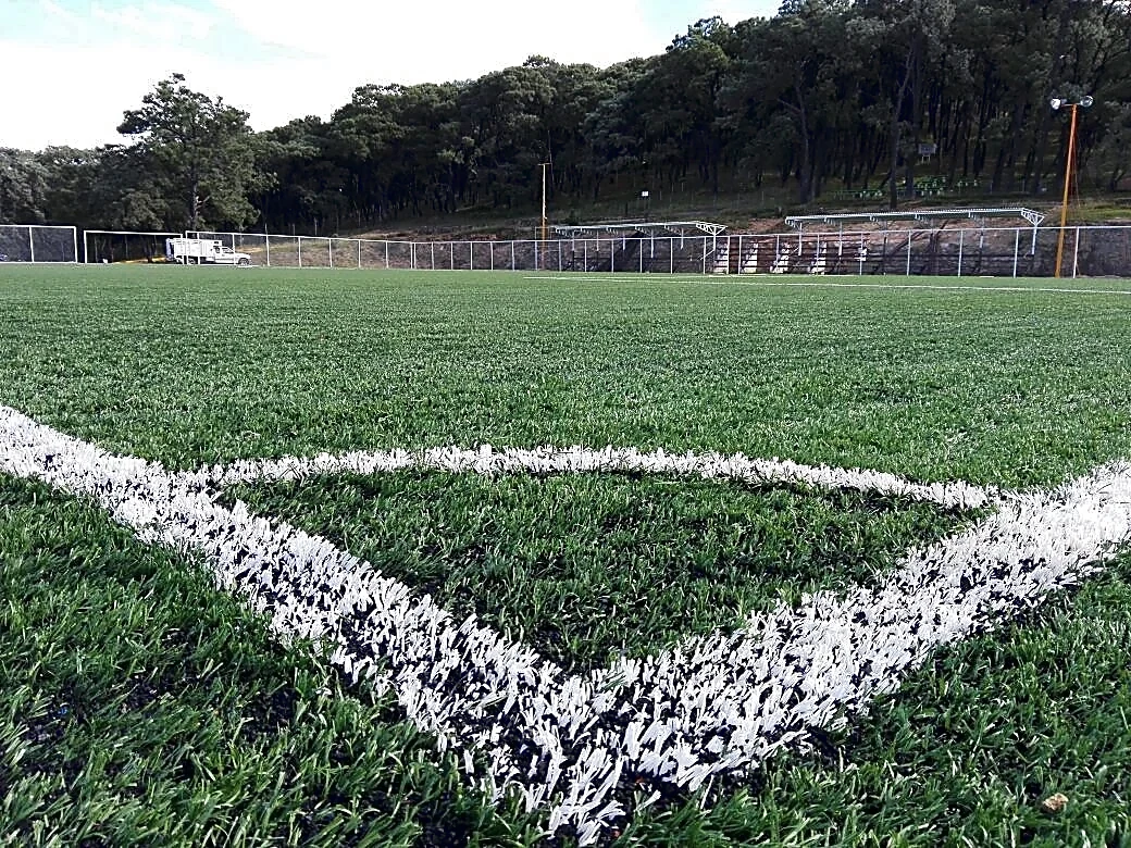 Cancha de fútbol soccer con pasto sintético en Campo Santiago Tamaozla, Tlaxiaco, Oaxaca: pasto sintético deportivo recién cepillado