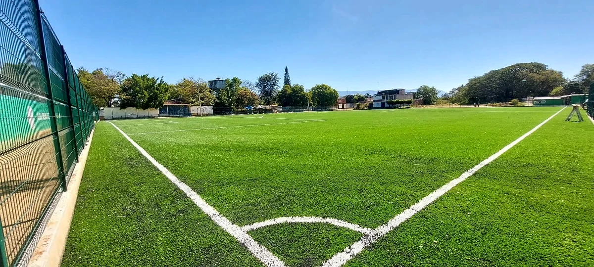 Cancha de fútbol soccer con pasto sintético en Ocotlán de Morelos, Oaxaca: pasto sintético deportivo recién cepillado