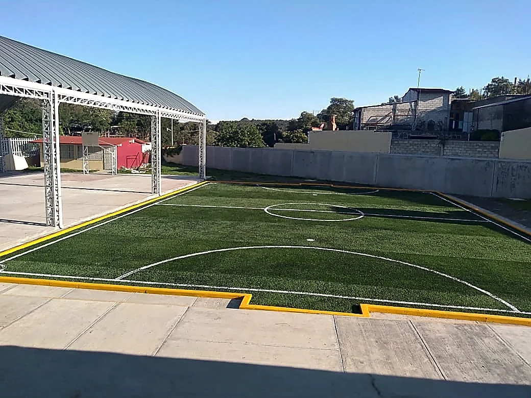Cancha de fútbol 5 con pasto sintético en Secundaria Lic. Álvaro Gálvez, San Nicolás de los Ranchos, Puebla: otra vista de la cancha