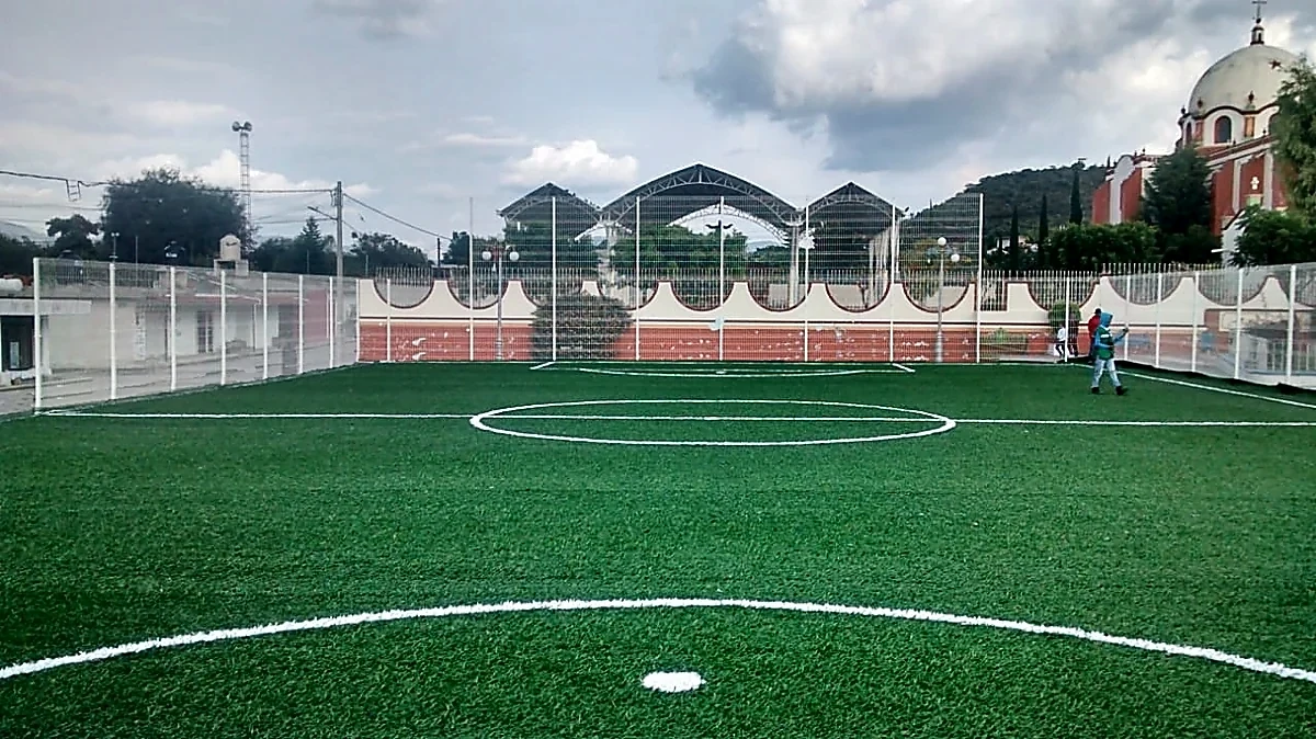 Cancha de fútbol 7 con pasto sintético en Campo Deportivo de la Colonia Tepehuey, Tetzoyocan, Puebla: líneas de juego insertadas en el mismo pasto